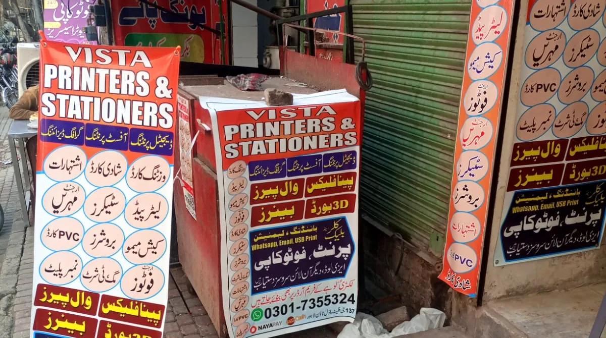 Vista Printers boards and banner cart outside the shop at Central Flats, Model Town Extension